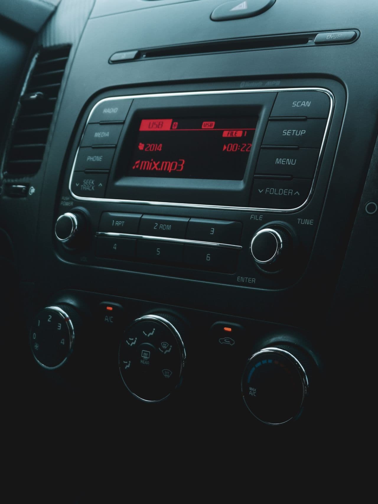 Vehicle centre console: head unit, illuminated display and climate dials.