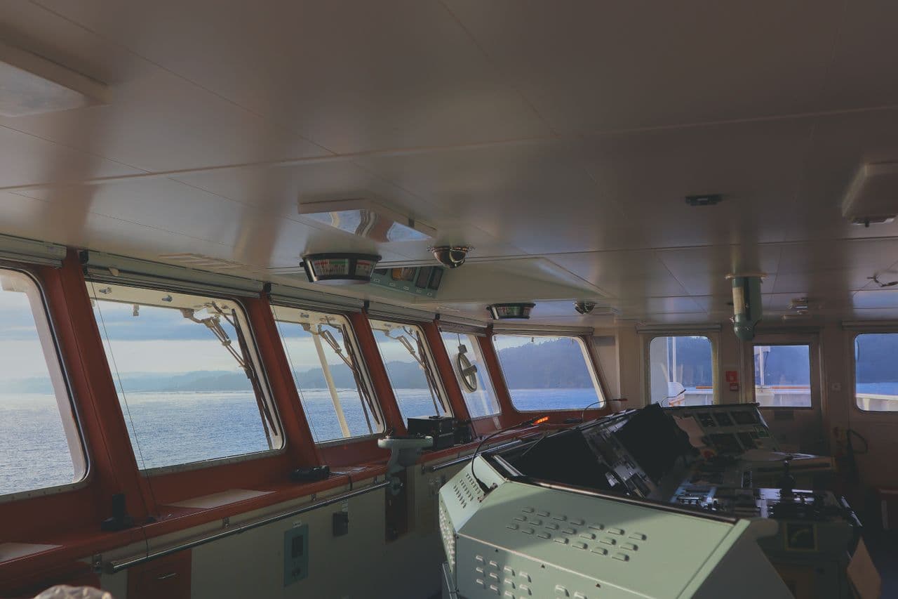 A ship's bridge, its console and forward windows.