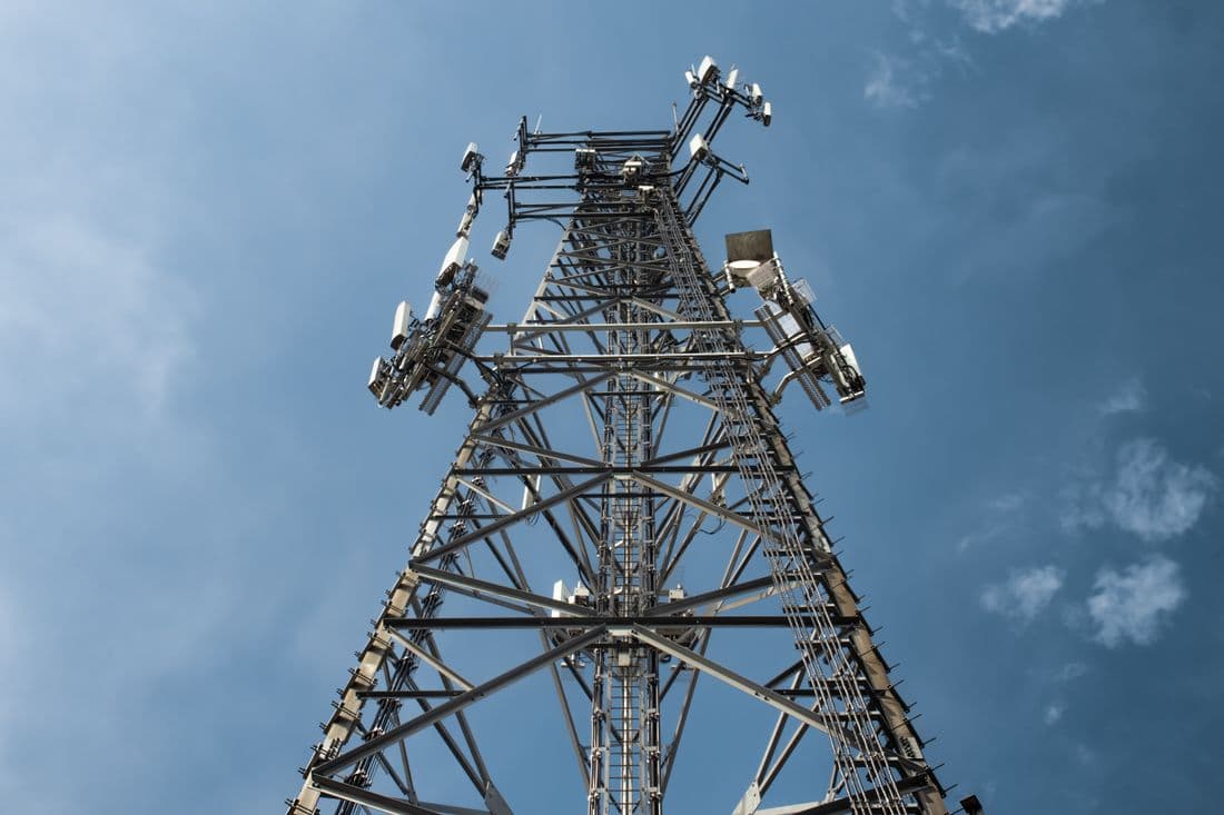 A telecommunications mast carrying several antenna arrays against the sky.